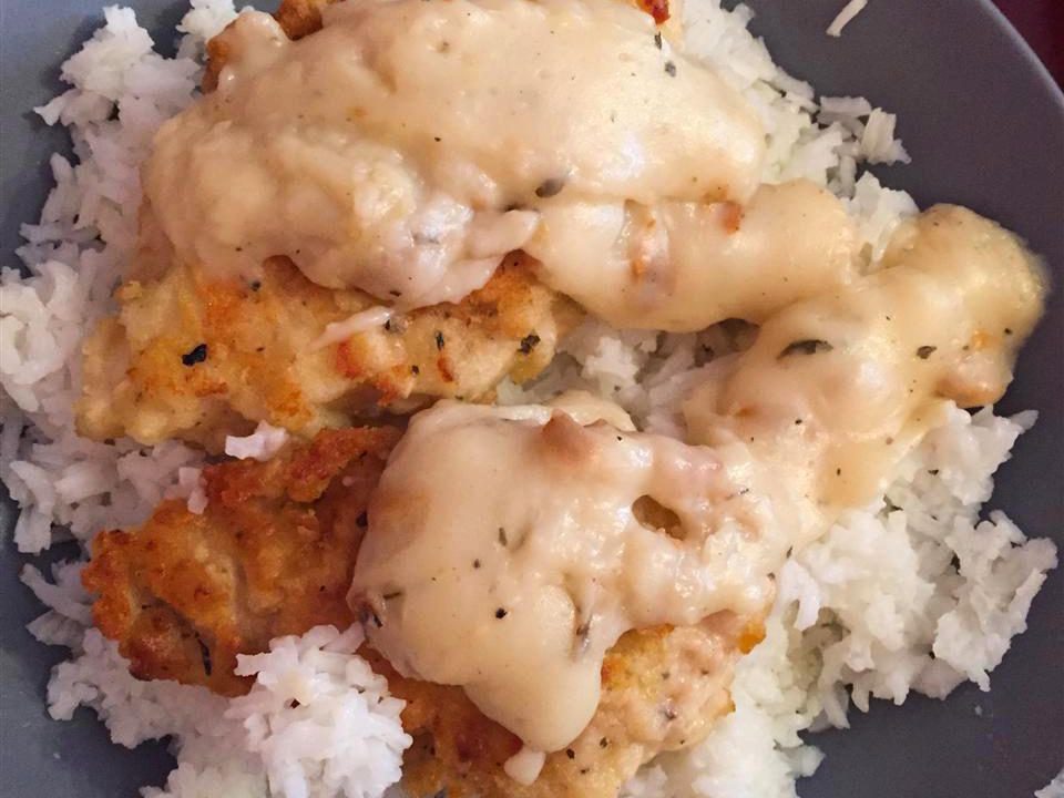 Poulet pané nappé d'une sauce crémeuse, servi avec du riz blanc