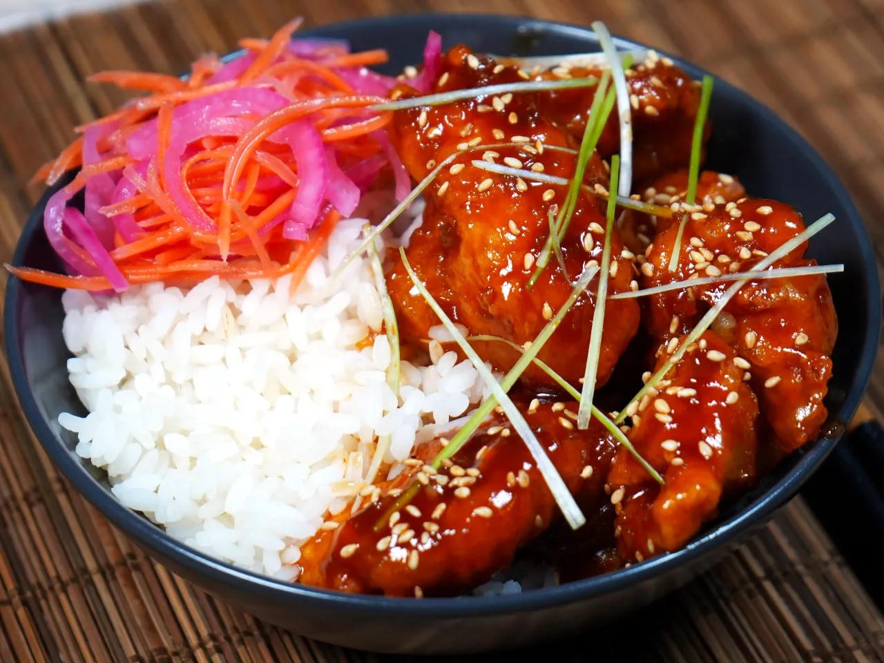 Poulet frit laqué d'une sauce rouge relevée, sur du riz blanc